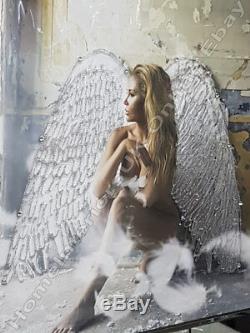 An angel white wings sitting in a room with crystals, liquid art & Mirror frame